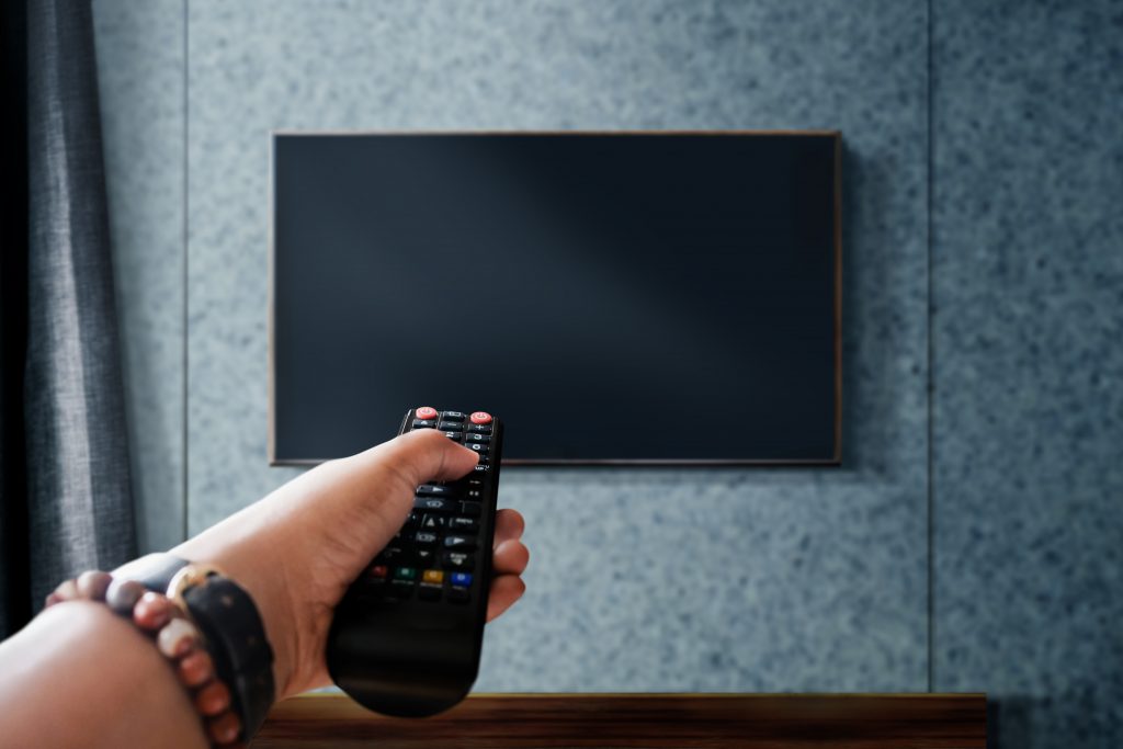 watching television concept hand holding tv s remote control changing channel scaled